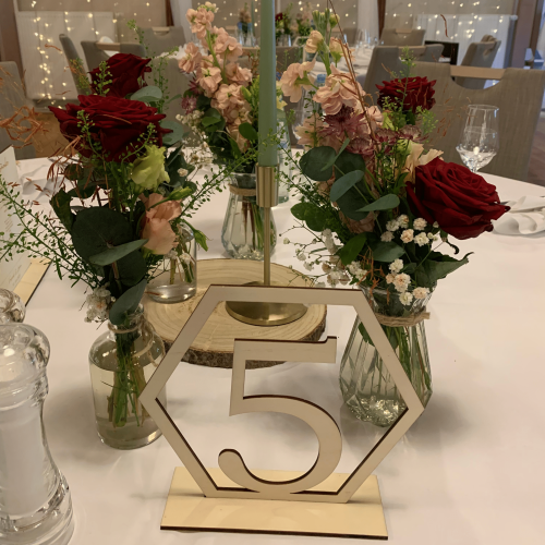 Dekortiert Hochzeitstisch mit Rosen und der Tischnummer 5