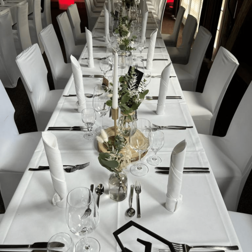 Gedeckter Hochzeitstisch mit Kerzenhalter und Baumscheiben